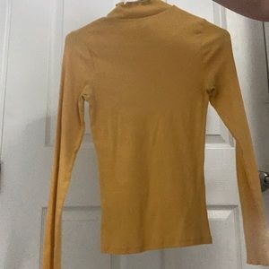 A yellow hollister turtle neck with ruffles.